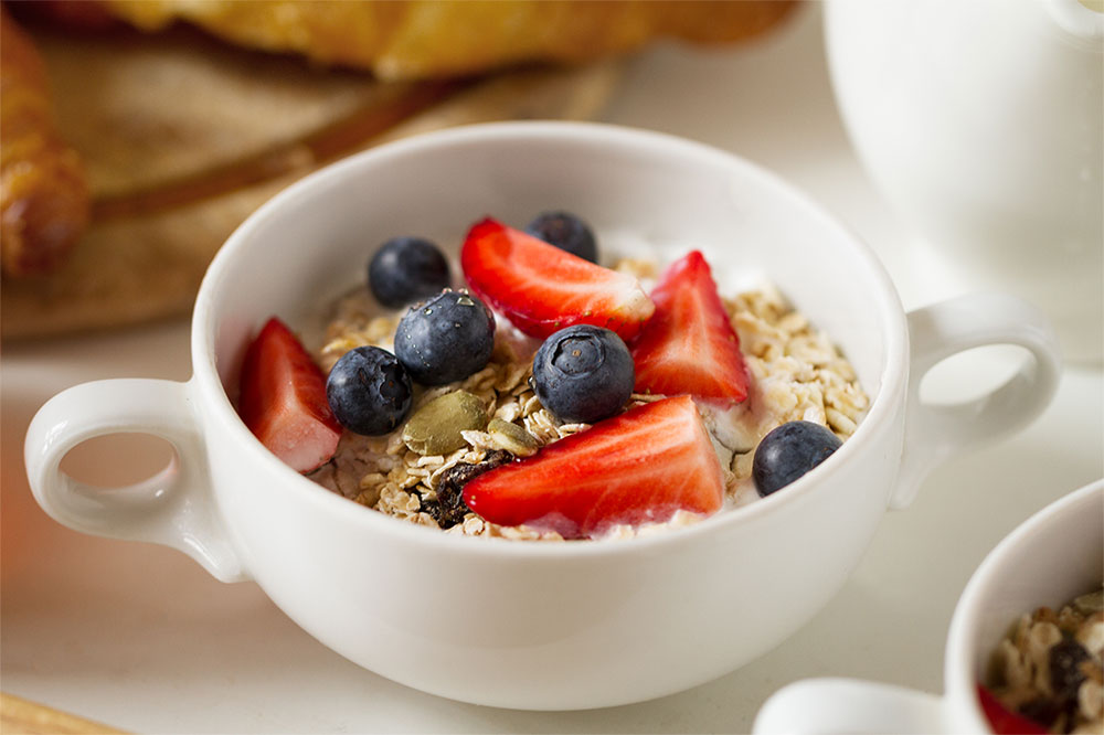 Bowl of yogurt with oats, strawberries and blueberries